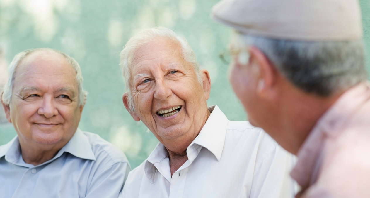 Three men talking, smiling